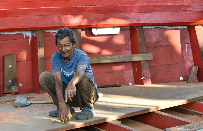 A member at work repairing a boat deck in the shop