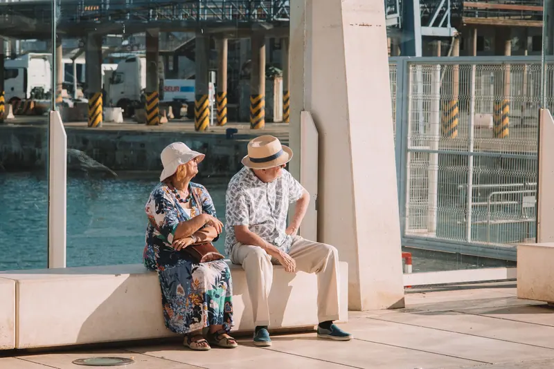 Two residents on a bench by the front door