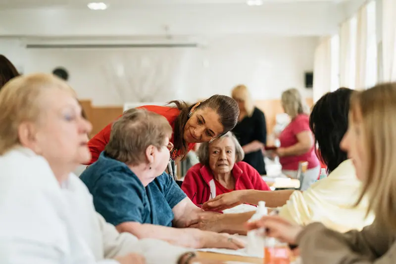 Members and staff laughing together around a table in the big room