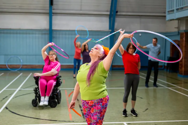Hoop class on the floor, one member joining from her wheelchair