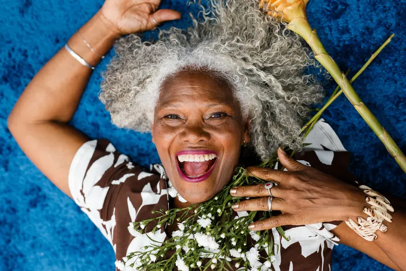A member laughing with flowers from the garden