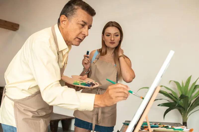 Members painting at easels in the art studio