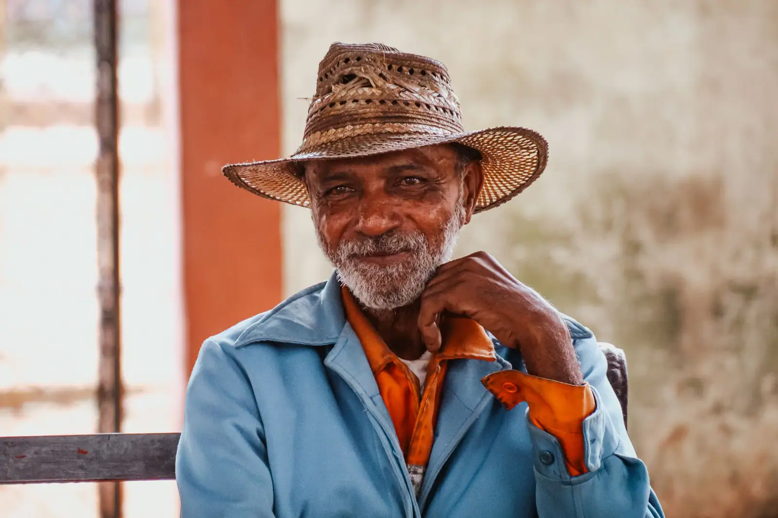 A longtime member in his straw hat on the bench outside the front door