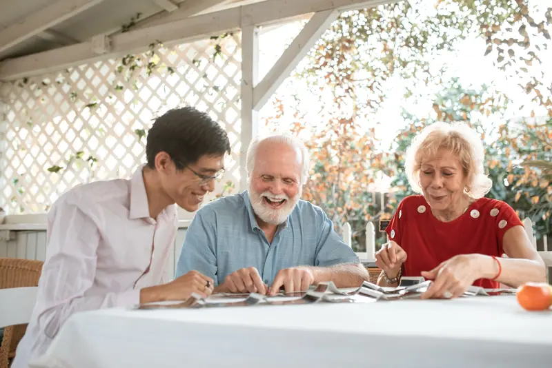 Members looking through old photographs together at a table outside