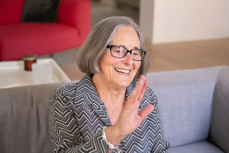 A longtime member waving hello from her chair by the window