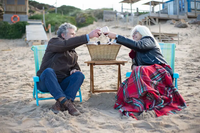 A member and his wife toasting with lemonade on the lake beach