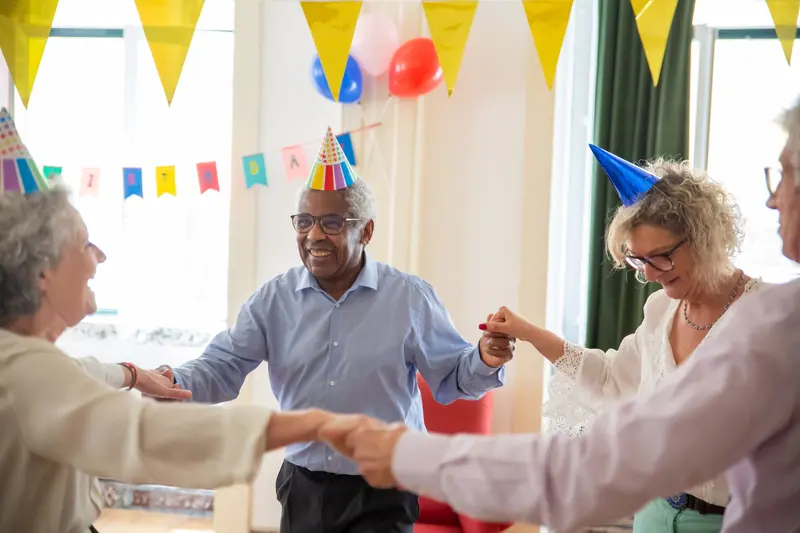 A member's birthday party with paper hats and cake