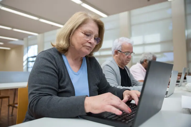 A member typing an email to her grandson in the computer corner