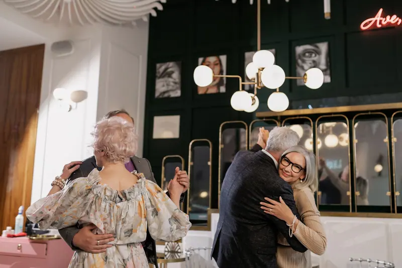 Friends hugging hello in the coffee room