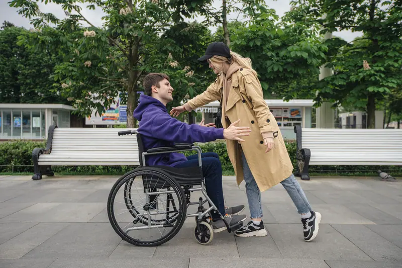 A therapist walking alongside a resident in his wheelchair