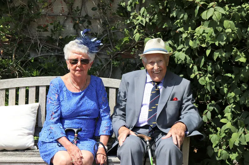 A couple dressed for church sitting together on the garden bench