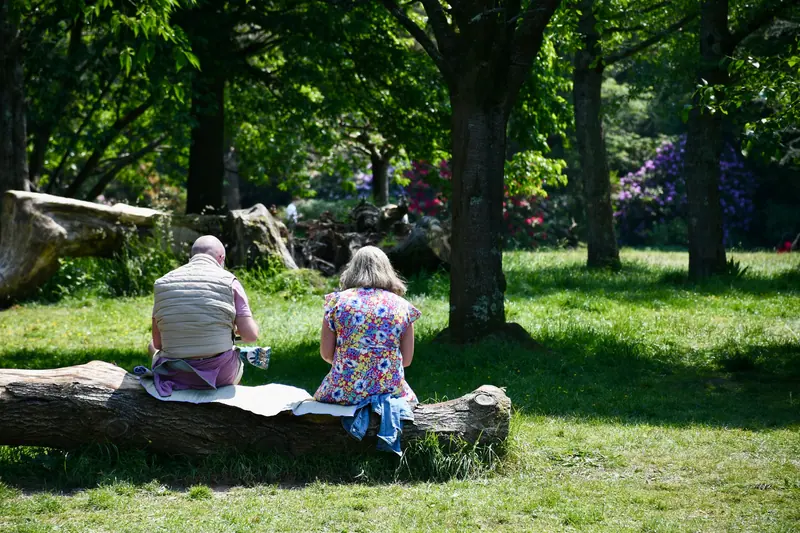 A resident resting with her rollator in the shade