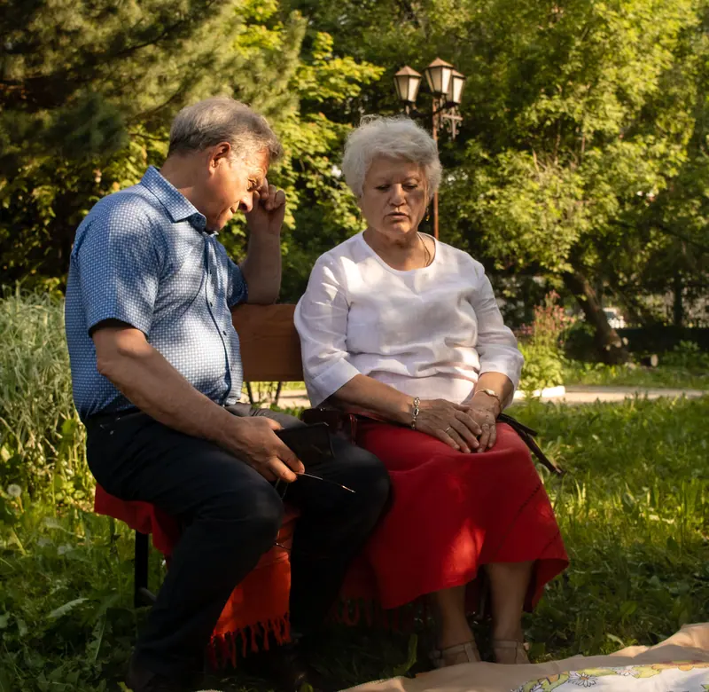 Husband and wife sitting together under the trees