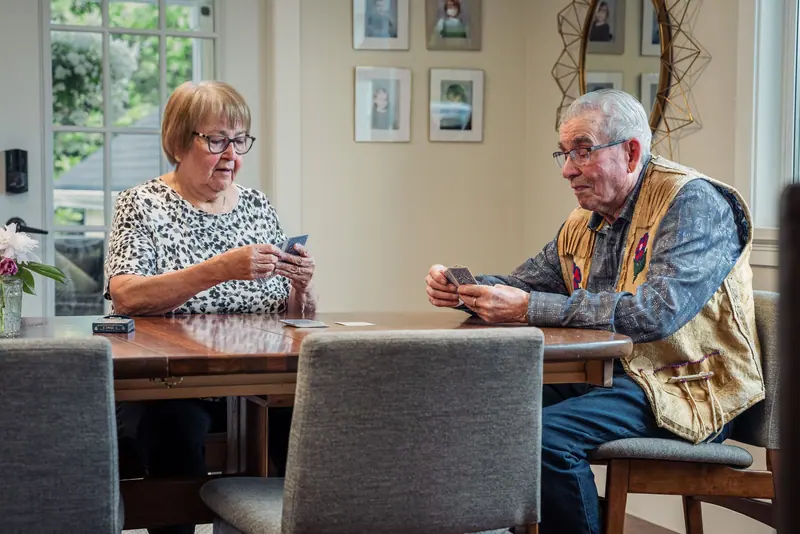 Residents playing a round of cards at the parlor table