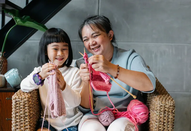 A resident knitting with her granddaughter on a Saturday visit