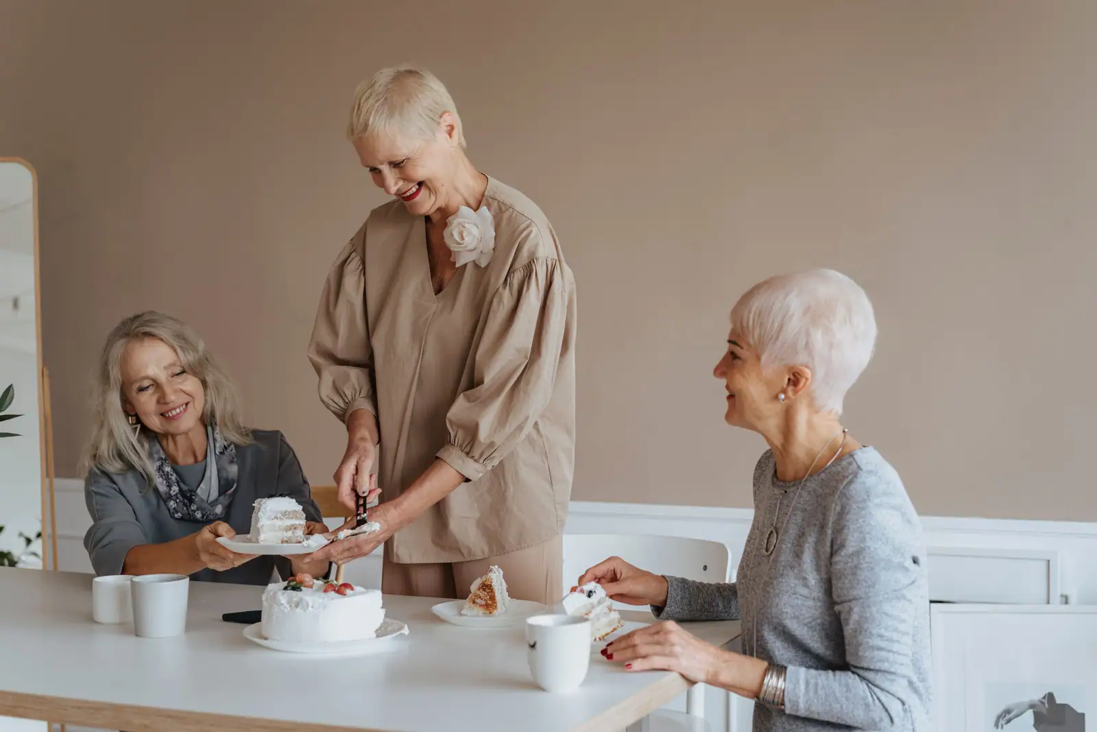 Three friends cutting a birthday cake