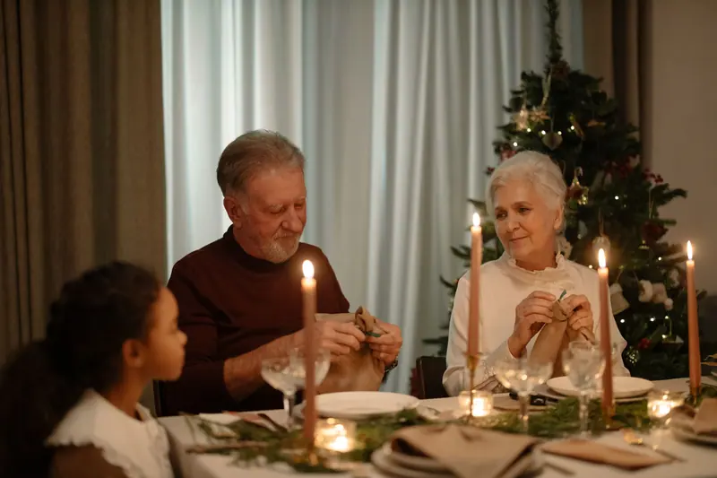 Residents and a granddaughter at a candlelit holiday dinner