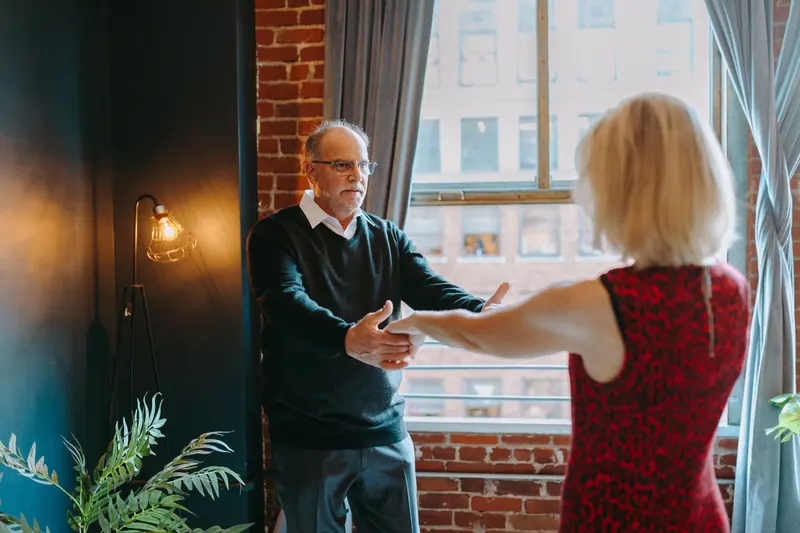 A couple dancing by the tall windows of the lobby