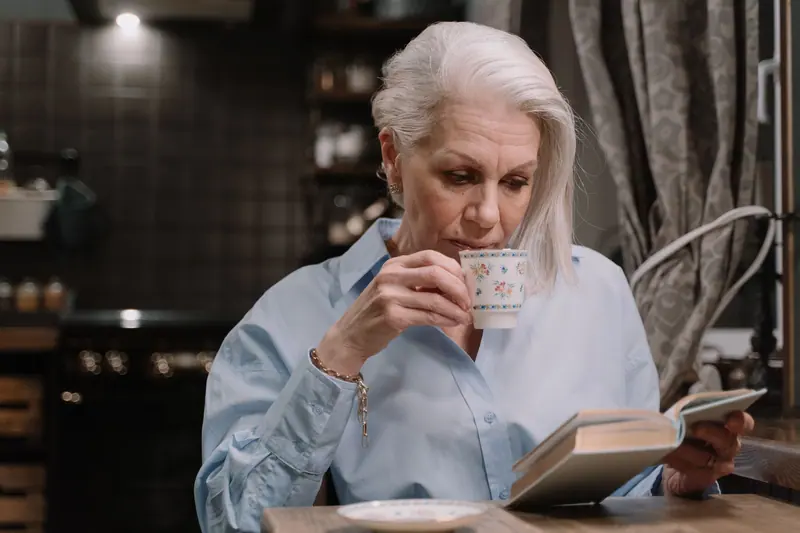 A resident reading with her morning tea