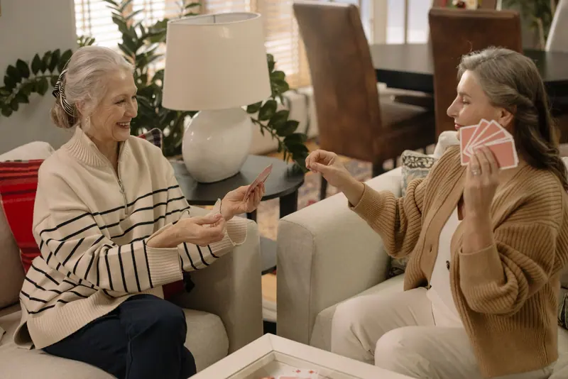 Two residents laughing over a hand of cards