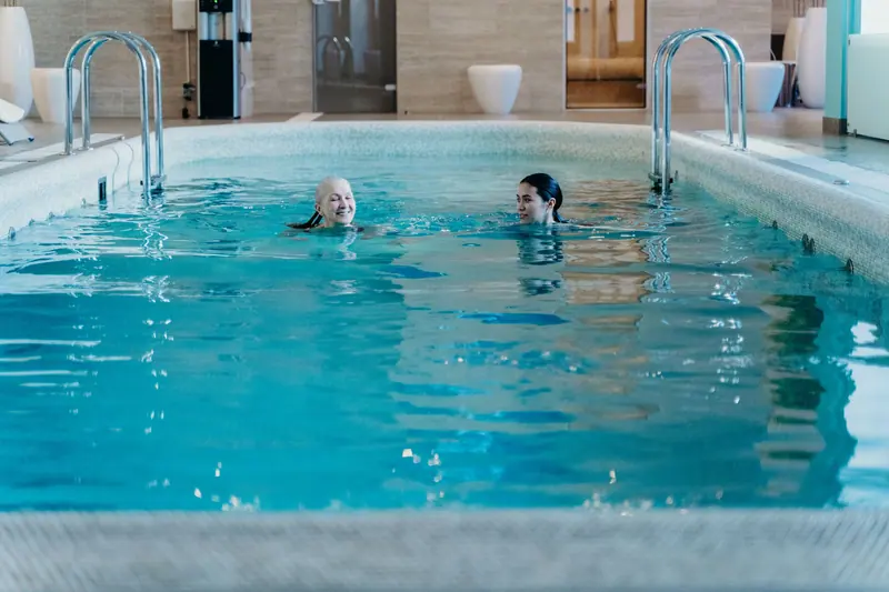 A resident and her daughter swimming in the warm-water pool