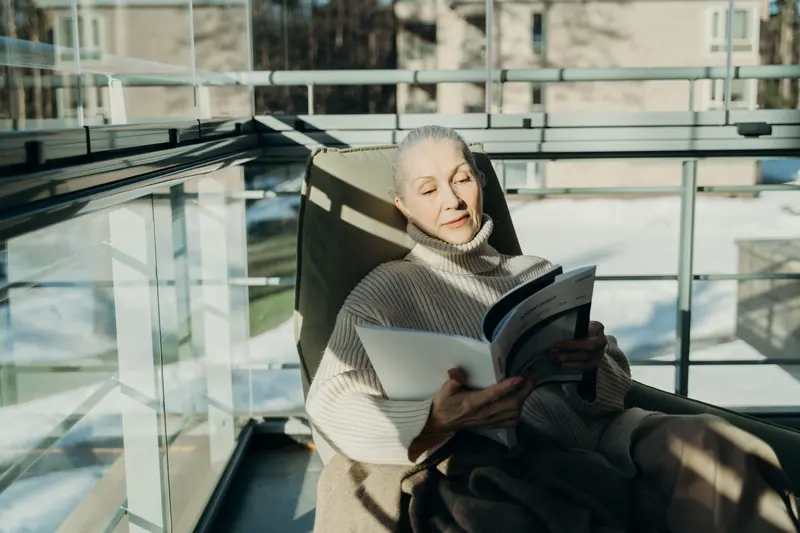 A resident reading by the tall window