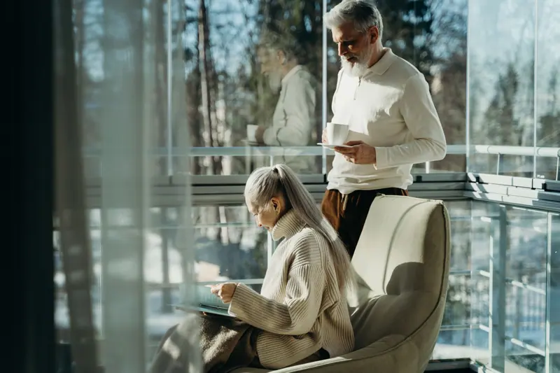 A couple reading in the sunroom on a winter afternoon