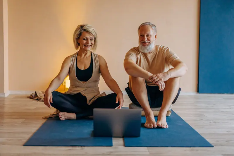 A couple doing chair yoga stretches together