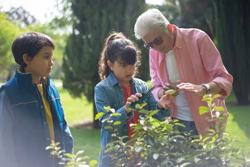 A resident showing his grandchildren a new plant