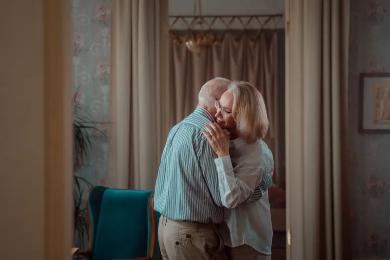 A couple holding each other close in their apartment