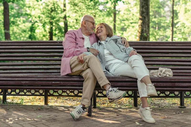 A couple laughing together on a garden bench