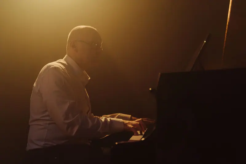 The evening pianist under a single warm light