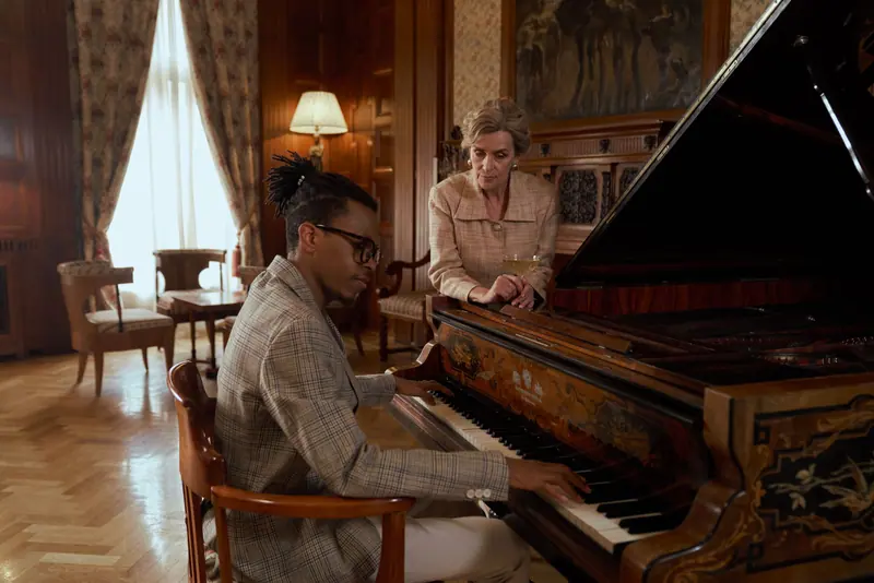 A resident listening to a piano lesson in the parlor