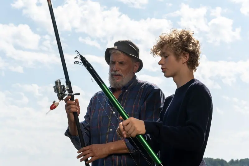 A grandfather and grandson rigging their rods