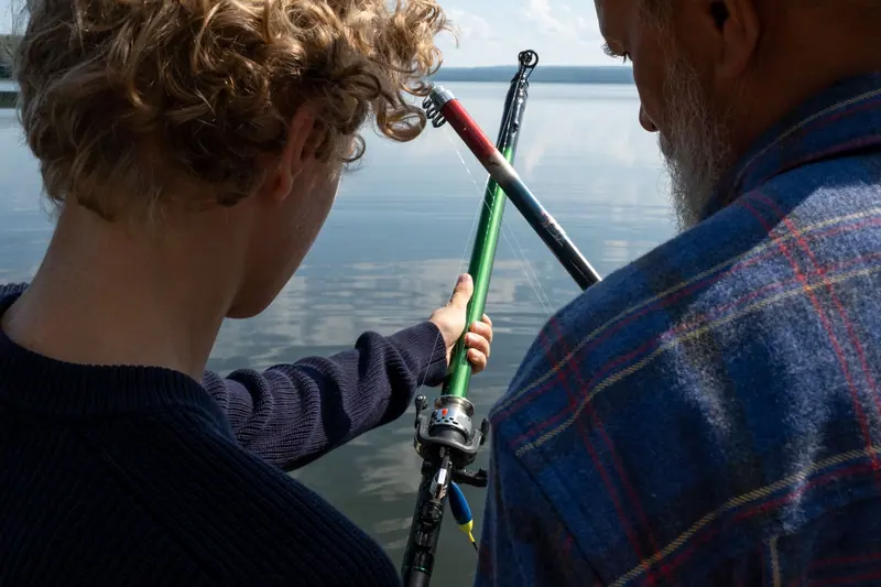 A grandfather teaching his grandson to cast