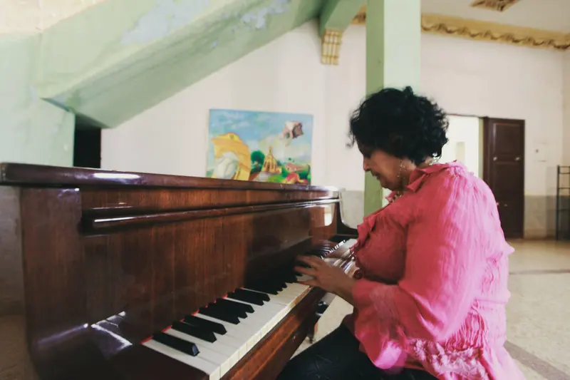 A resident playing the piano in the music room