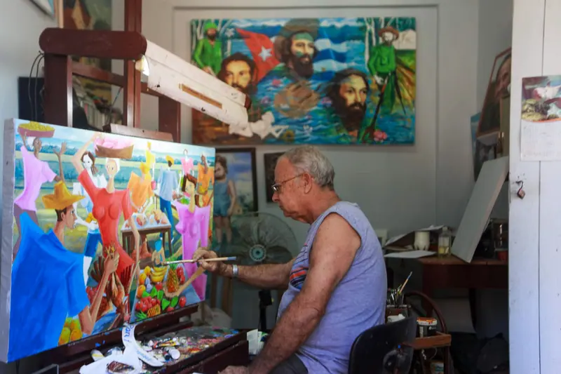 A resident painting a mural in the studio