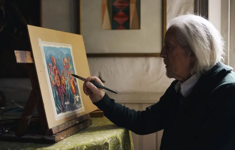 A resident painting at her easel