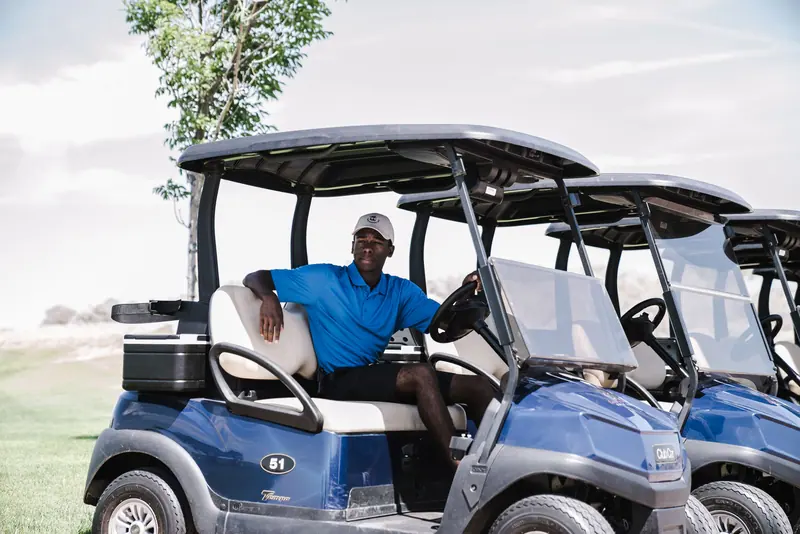 A resident in a golf cart at the course