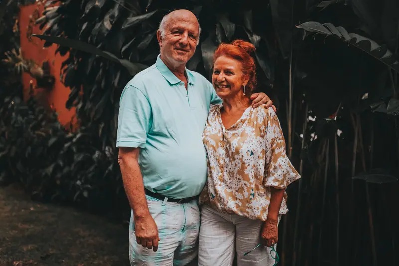 A couple smiling together in the greenery