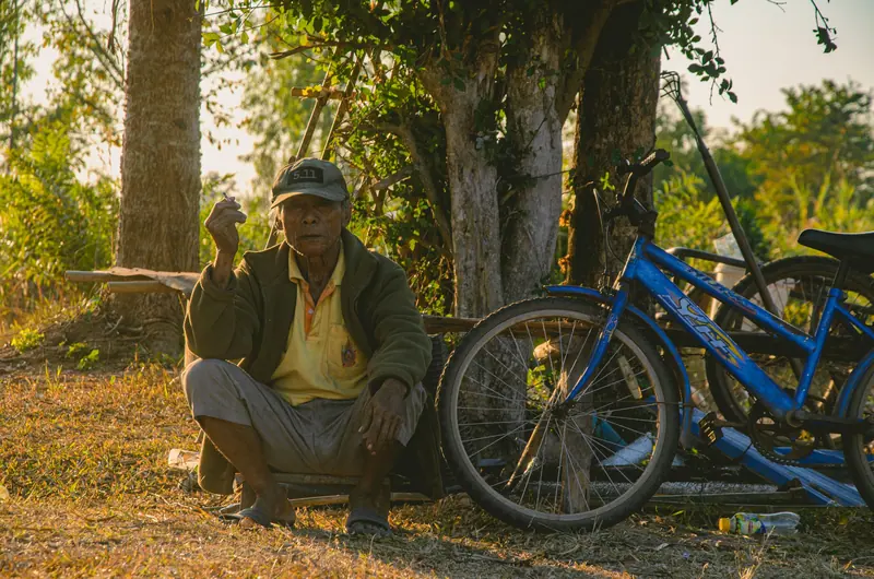 A resident resting beside his bicycle