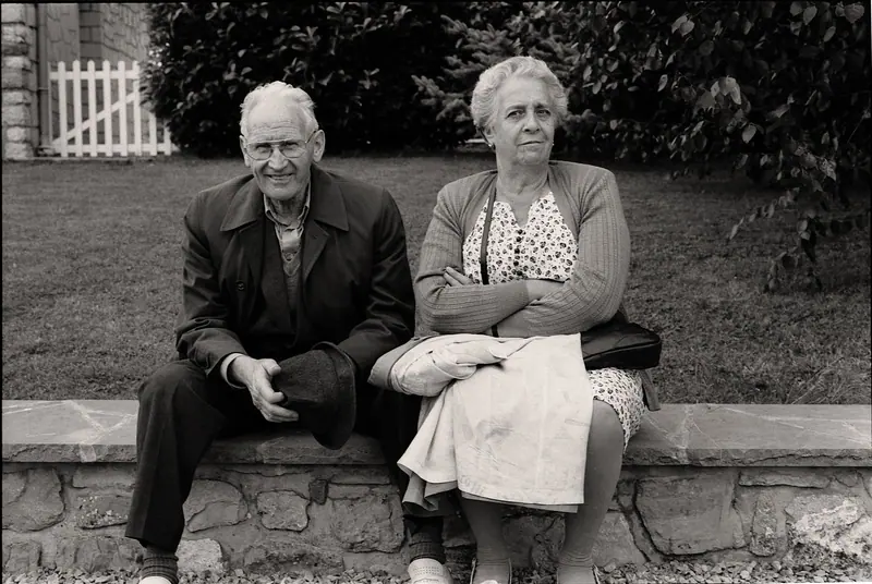 A husband and wife sitting together on a stone wall
