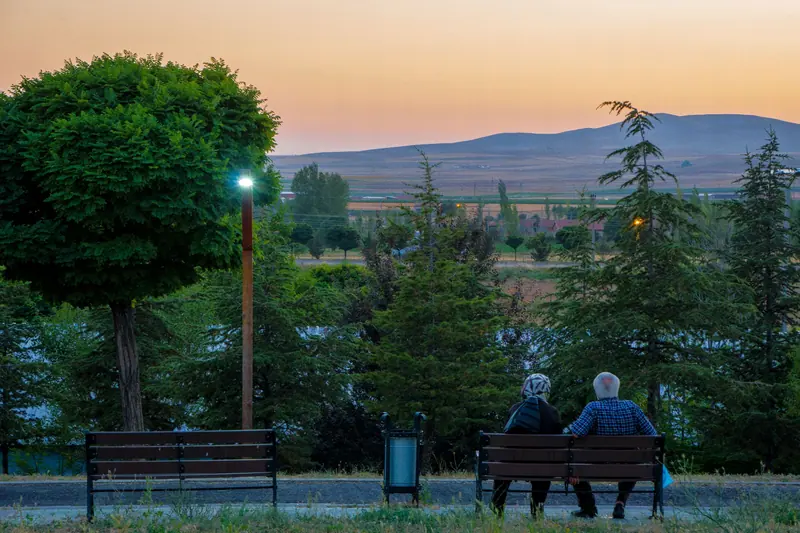 A couple on benches at sunset