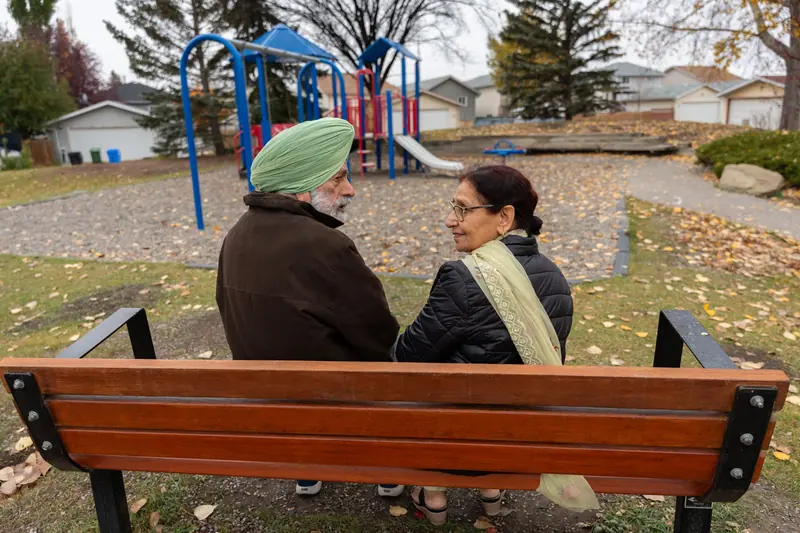 A couple on a bench in fall