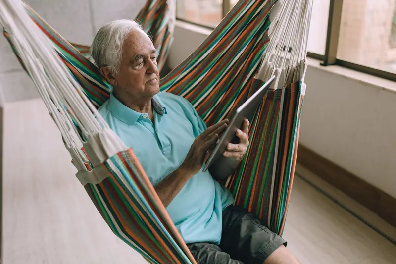 A resident reading in a hammock on the sun porch