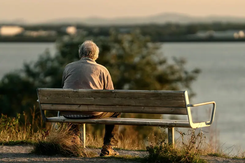 A resident on a bench by the lake