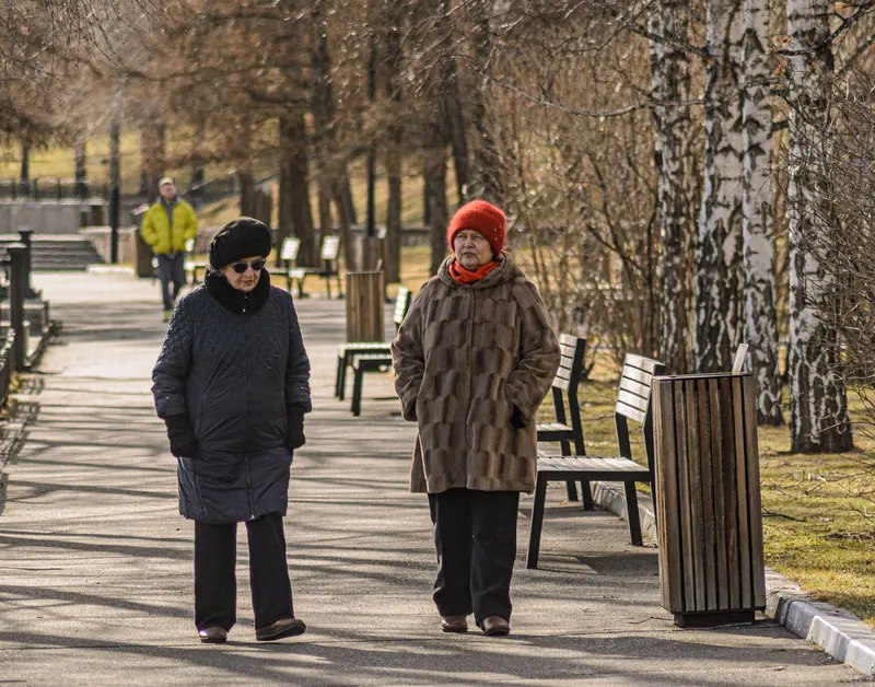 Two friends walking the shore path in early spring