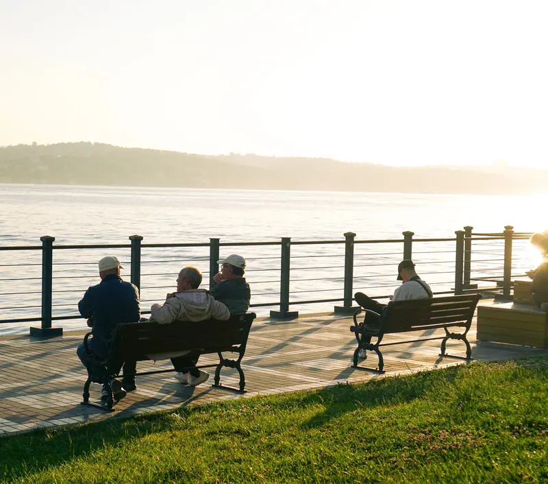 Friends on the seawall benches at sunset