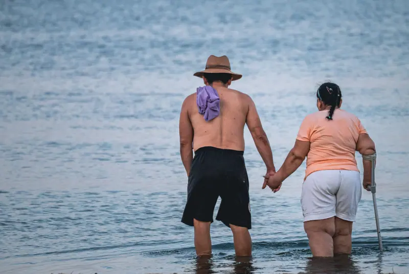A couple wading into the river hand in hand