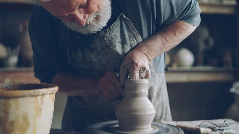 A resident throwing a pot in the pottery studio